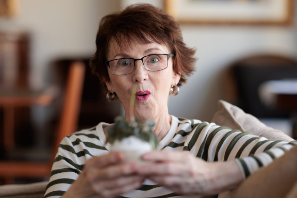 微笑的女人拿着一盆植物图片下载