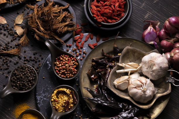 深色木桌上的各种东方泥土味干香料，如姜黄，黑胡椒，辣椒片，月桂叶，用于治疗和烹饪的药用和草药用途图片下载