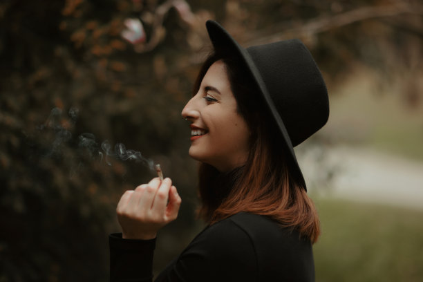 年轻的红发女子肖像拿着香烟和微笑广泛图片下载