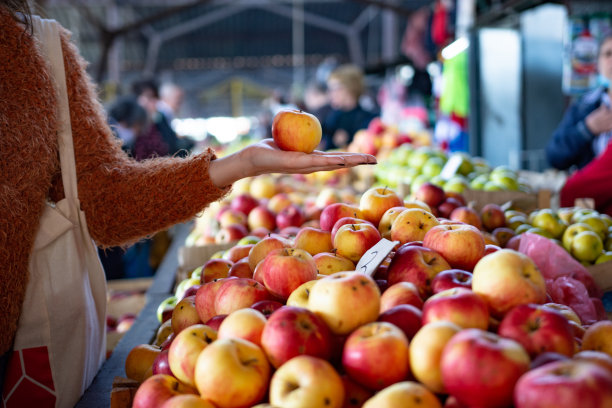 一名年轻女子在当地食品市场购买新鲜水果和蔬菜的照片图片下载