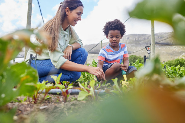 一个有吸引力的年轻女人和可爱的小男孩在农场工作的全长镜头图片下载