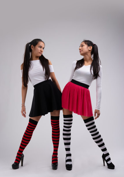 两个时尚的年轻模特穿着条纹紧身裤摆姿势图片下载