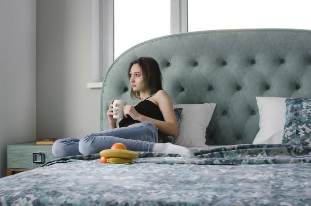 一个漂亮的女孩在床上吃早餐和喝茶。生活理念，美丽内饰。图片下载