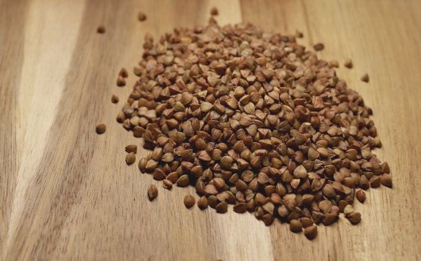 在木制背景上堆荞麦。荞麦粥是俄罗斯的传统食品图片下载