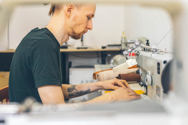 近手工匠用缝纫机为钱包空白缝东西。在皮革车间工作图片下载