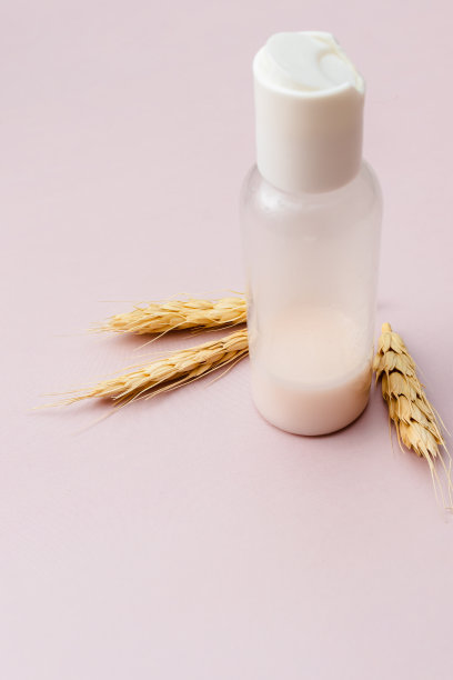 容器内装护肤产品，供美容晨间例行使用。用于面部和身体护理的有机化妆品。小麦在粉红色的背景。垂直照片，复制空间。图片下载