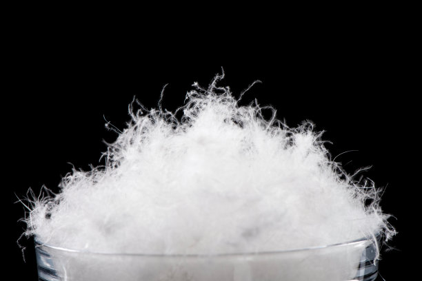 在黑色的背景上柔软蓬松的白色羽绒。图片下载