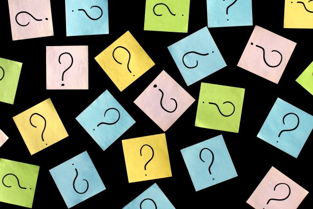 带有问号的贴纸贴在黑色的背景上。图片下载