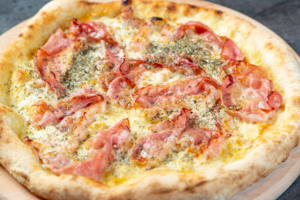 特写烤披萨与融化的马苏里拉奶酪和培根片，牛至调味料图片下载