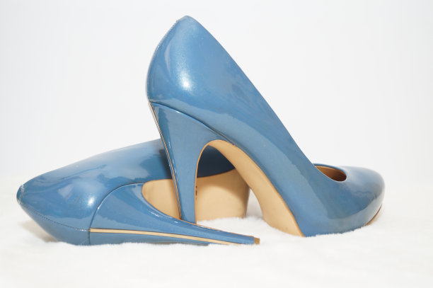 白色地毯上蓝色性感的高跟鞋。图片下载