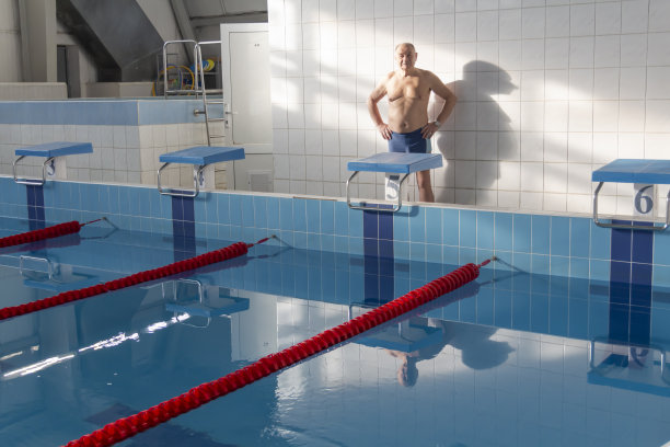 一位老人在一个退休的运动中心的游泳池里积极地从事游泳和运动。图片下载