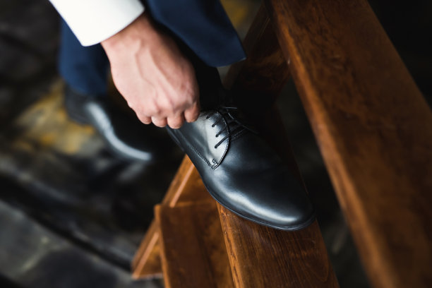 男人在木地板上系鞋带。图片下载