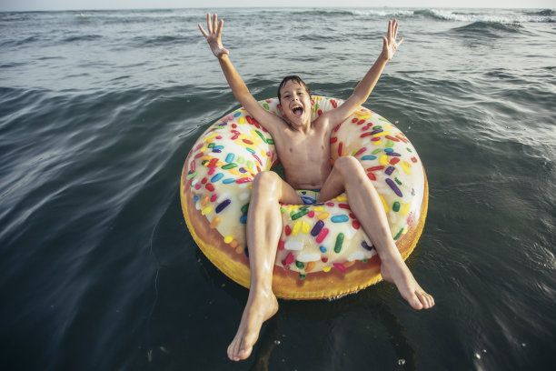 快乐的孩子在充气环上冲浪。图片下载