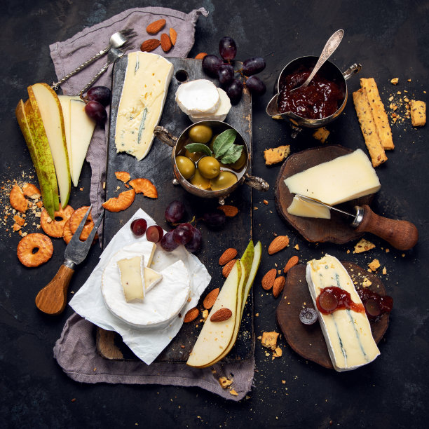 奶酪板在黑暗的背景。图片下载