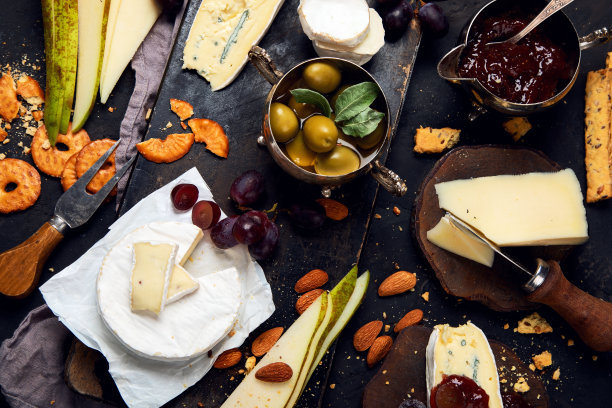 奶酪板在黑暗的背景。图片下载