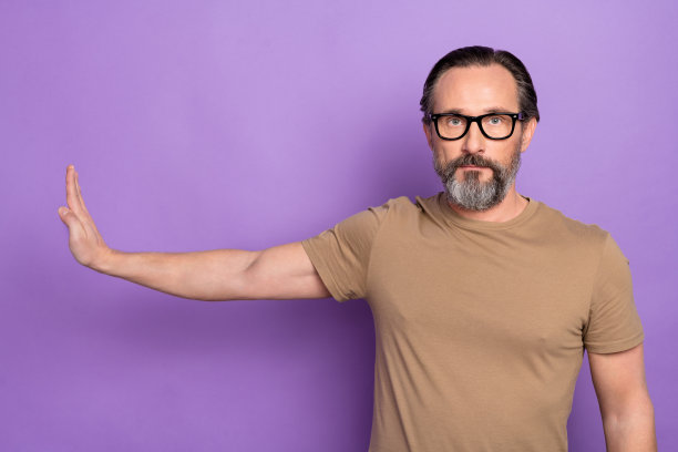 英俊严肃的男人的照片显示停止标志反对酒精和不健康的生活方式孤立在紫色的背景图片下载