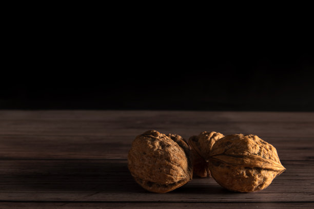 胡桃在黑色背景木制桌子的顶部。图片下载