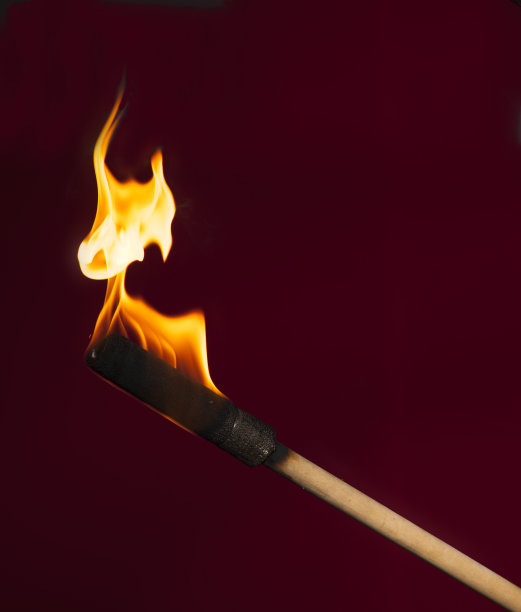 燃烧的火炬在一个木制基地的特写勃艮第背景与空白的文字空间图片下载