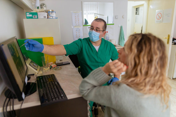 男正畸医生与女病人交谈，向她展示牙科x光片图片下载