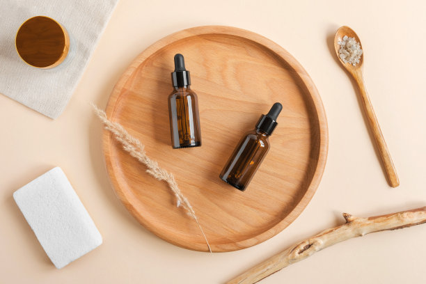 深色琥珀色玻璃瓶，木盘上放着干花。天然护肤SPA美容产品设计。矿物有机油在米色背景化妆品。实物模型。油性吸管。面部及身体护理图片下载