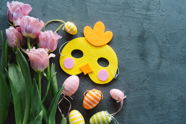春天的郁金香和五彩缤纷的复活节彩蛋在木制的背景上。图片下载