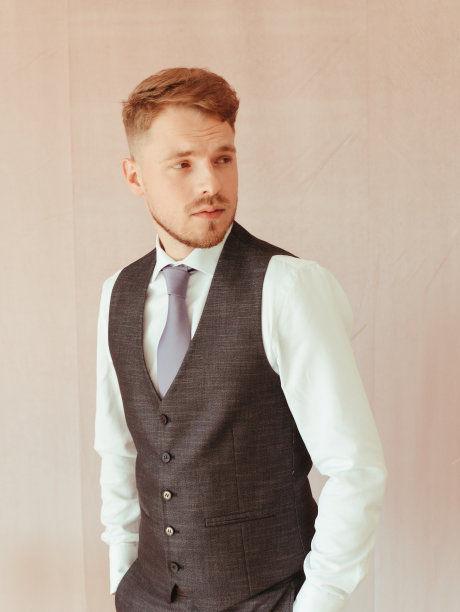 时尚的年轻人穿着黑色燕尾服，纹理效果工作室的金发图片下载