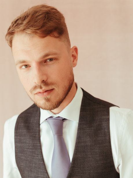 时尚的年轻人穿着黑色燕尾服，纹理效果工作室的金发图片下载