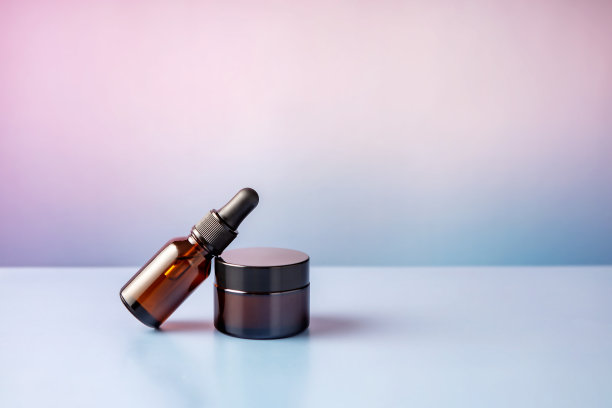 棕色玻璃容器化妆品在粉紫色梯度背景图片下载