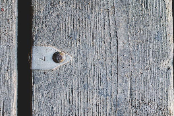 灰色木质表面钉有铝标签。标签上凸印着数字7。粗糙的旧木板。木材的质地。图片下载