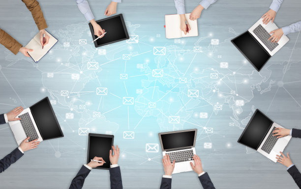 一群手持设备的人在笔记本和平板电脑上工作图片下载