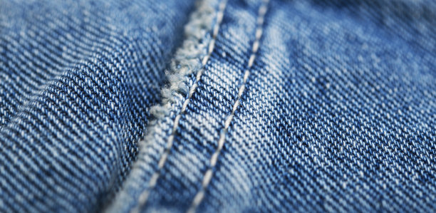 旧的蓝色牛仔裤背景和纹理接近。牛仔布缝。图片下载