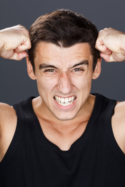 用手抓着脑袋的年轻人的肖像。头压力抽烟。广场。图片下载