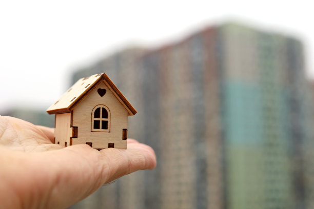 新建筑背景上的男性手木制房屋模型图片下载