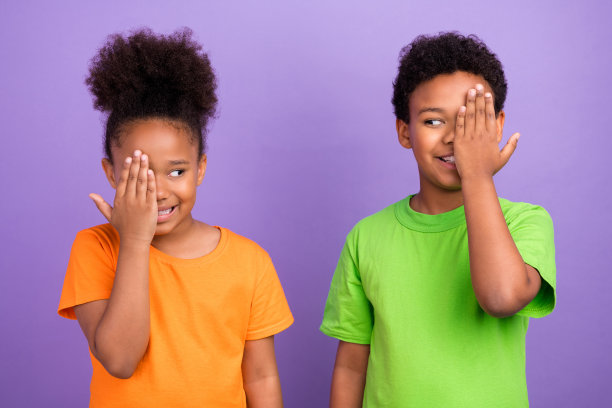 照片的两个年轻的非洲小孩快乐积极的微笑，闭上眼睛，有乐趣，好玩的孤立在紫罗兰色的背景图片下载