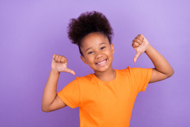 年轻快乐的小爆炸女孩快乐积极的微笑点大拇指她自己骄傲的赢家孤立在紫罗兰色的背景图片下载