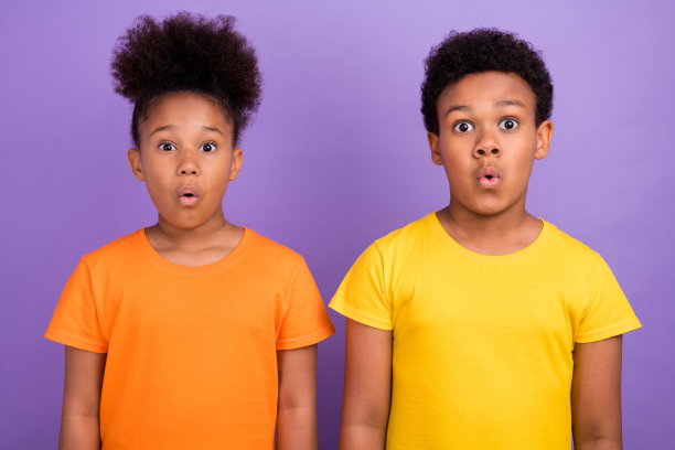 两个非洲裔小孩的照片惊讶，震惊，惊讶omg的假的新奇信息孤立在紫色的背景上图片下载