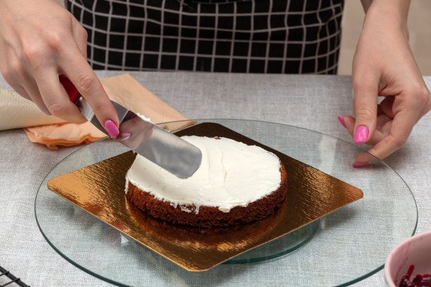用抹刀把海绵蛋糕上的奶油抹平。制作蛋糕的过程。有选择性的重点。图片是关于食品、糖果商的文章。图片下载