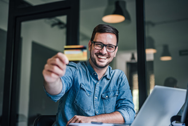 快乐的成年银行家的肖像，推广新的信用卡。图片下载