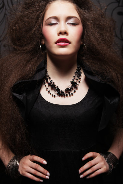 美丽的年轻黑发女人与卷曲的头发和明亮的化妆图片下载