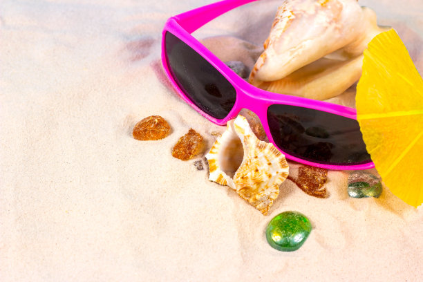 黄色沙质纹理背景与明亮的贝壳，太阳镜和石头与复制空间。海上度假旅游和热带度假概念图片下载