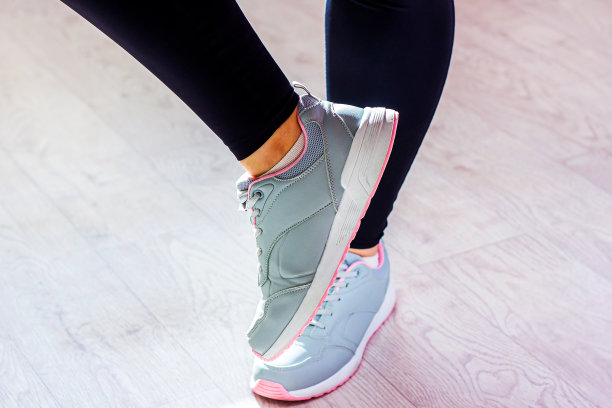 年轻女子穿着黑色的运动打底裤和运动鞋，在健身房的地板上穿着运动服。积极减肥，身体锻炼和锻炼，健身和健康的概念图片下载