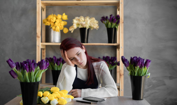 疲惫，沮丧，无聊的白人女性花店老板，因企业破产而沮丧，沮丧，紧张的担忧在工作上的问题。图片下载