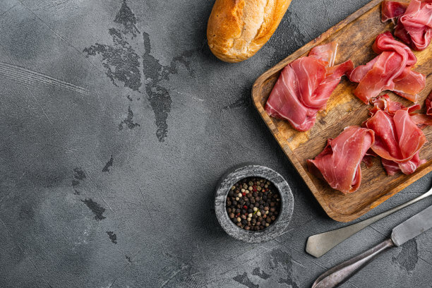 美味的西班牙火腿或火腿集，在灰色石头桌子背景，俯视图平躺，与文本复制空间图片下载