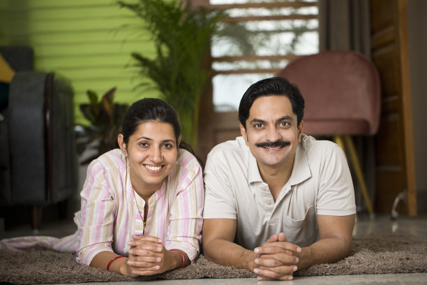 幸福的夫妻躺在家里的地毯上图片下载