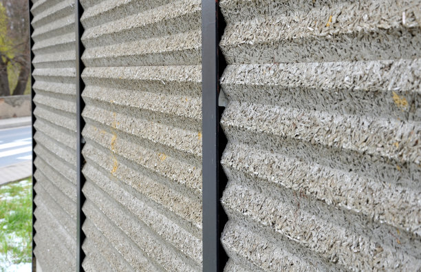 隔音墙由混凝土多孔肋材制成。街道上的金属横梁上插着棕色的栅栏。道路交通的噪声不会进入花园和住宅区。图片下载