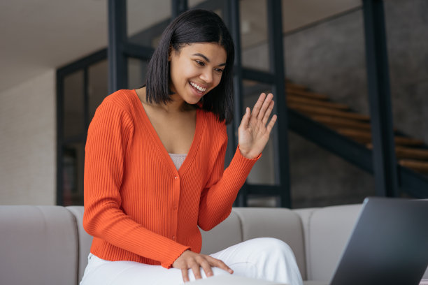 网红使用笔记本电脑录制视频，挥手与订阅者交谈。美丽的微笑的非洲裔美国妇女自由职业者有视频电话在线工作从家里。成功的商业图片下载