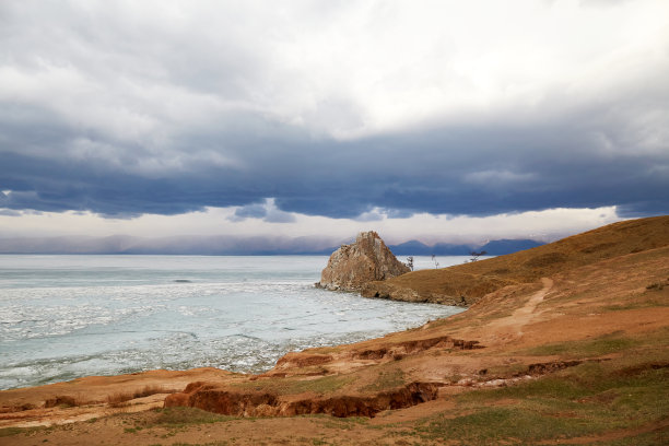在贝加尔湖浮冰期间，冰融化了。在阴云密布的春日，奥尔洪岛的布尔汗角或沙曼卡岩的美丽景色图片下载