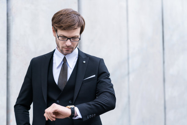 英俊的大胡子商人正在核对时间。图片下载