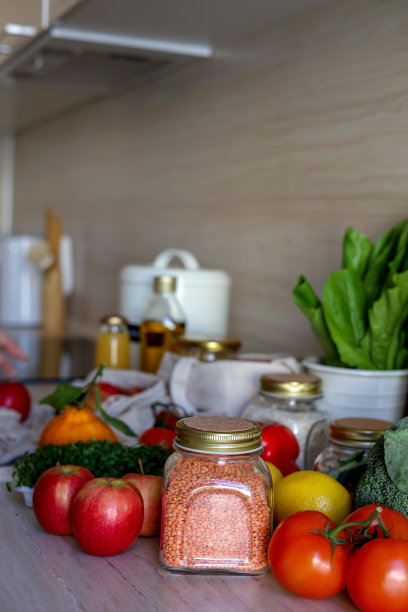 年轻的亚洲妇女从杂货袋里拿出一玻璃罐扁豆。可重用的包。“零浪费”。图片下载