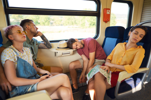 白种人朋友一起坐火车旅行，其中一些人睡觉图片下载